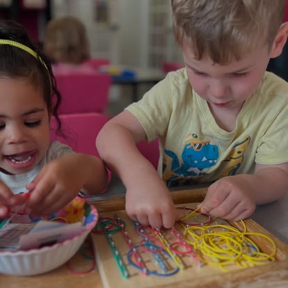 Children at The Growing Room exploring colorful materials together